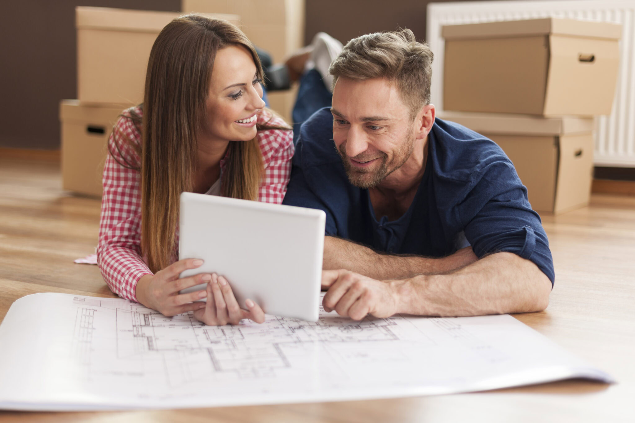 Couple arranging new apartment with digital tablet
