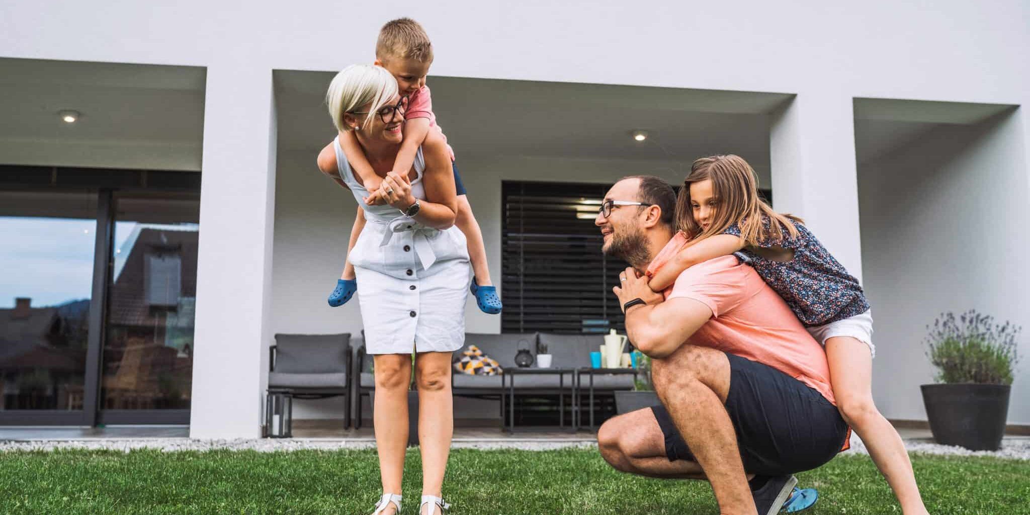 Happy caucasian family of four, mother father and children at home, outdoors playing on the grass, and indoors in the living room having fun as a family.