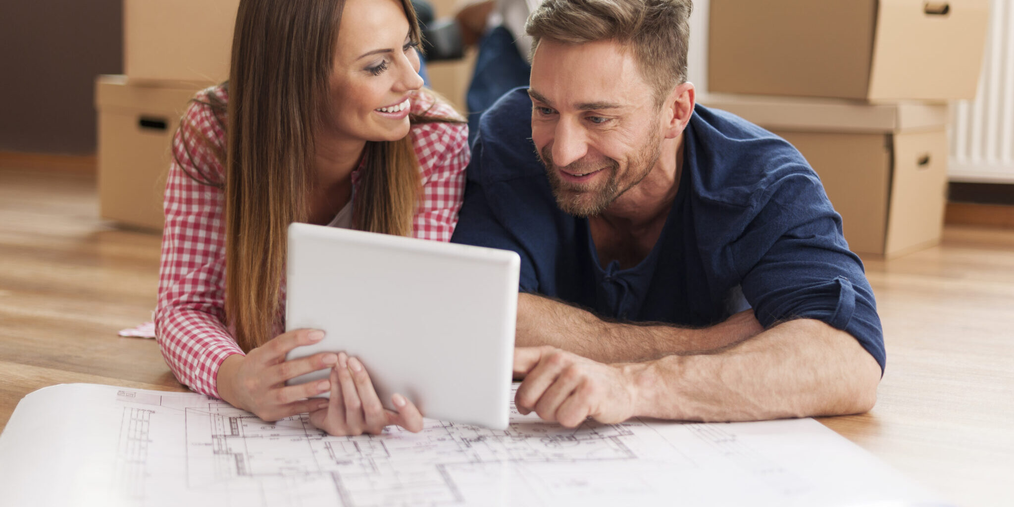 Couple arranging new apartment with digital tablet