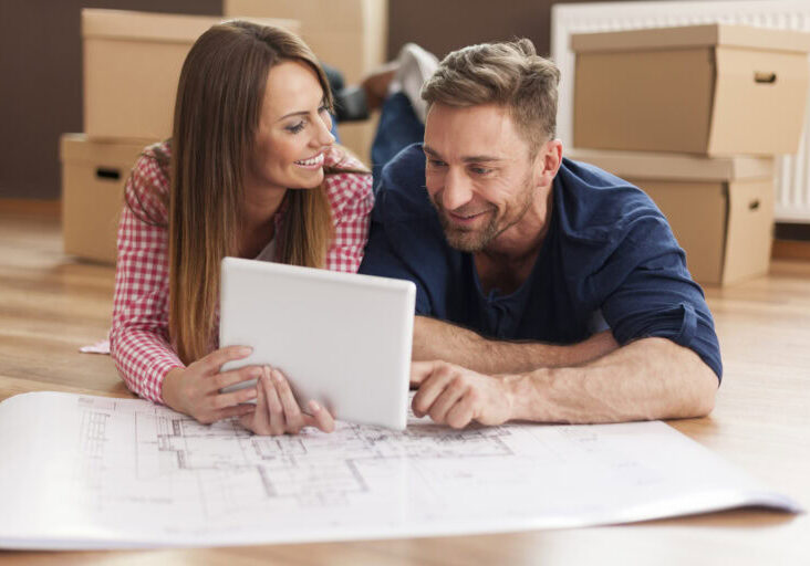 Couple arranging new apartment with digital tablet